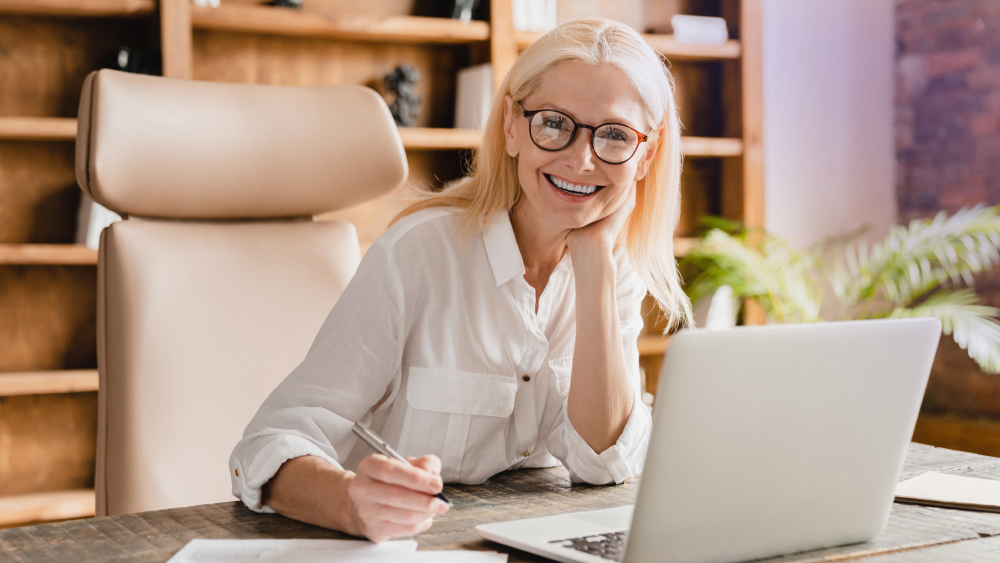 Happy client using laptop, satisfied with GrowTal's remote services.