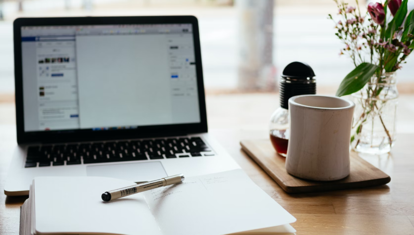 Open notebook and laptop on desk, ready for content writing