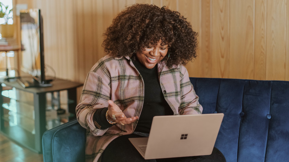 Person having a virtual meeting on a laptop, smiling and engaged